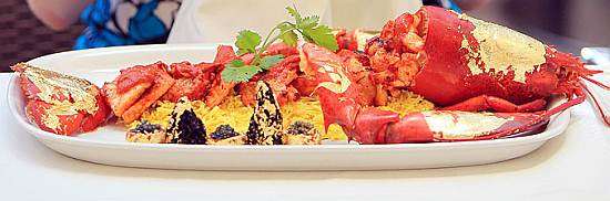 Humr potažený zlatem na talíři s rýží a kaviárem, nejdražší curry na světě z restaurace Bombay Brasserie