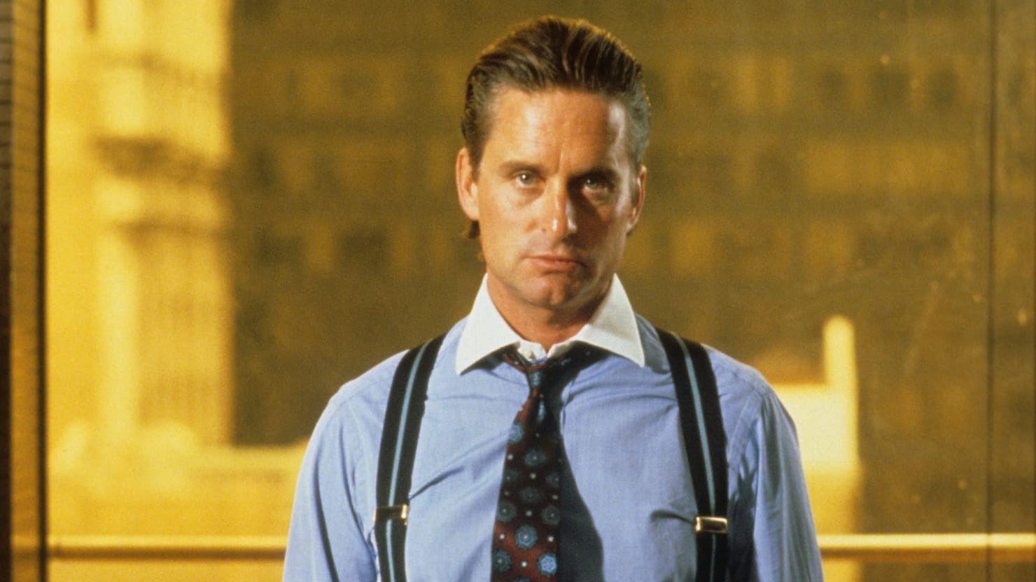Michael Douglas jako Gordon Gekko ve filmu Wall Street, v modré košili s kravatou a šlemi