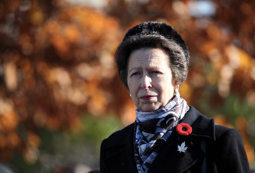 Zasmušilá Anne Mountbatten-Windsor pochoduje v podzimním počasí oblečená do černého kabátu a šály.