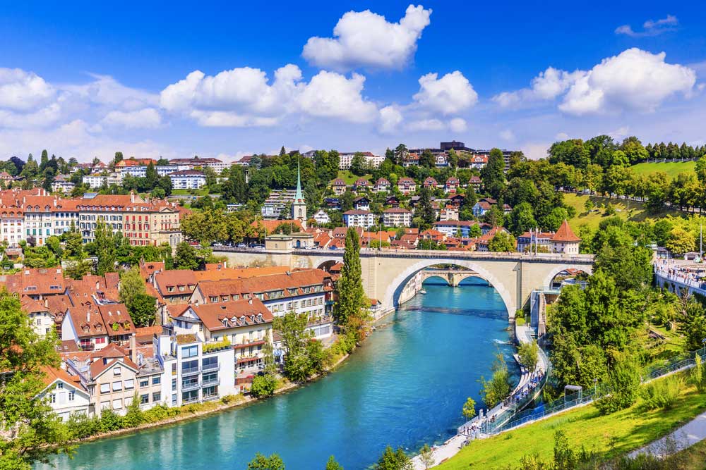 Pohled na město Bern s řekou Aare, obloukovým mostem a středověkými domy s červenými střechami
