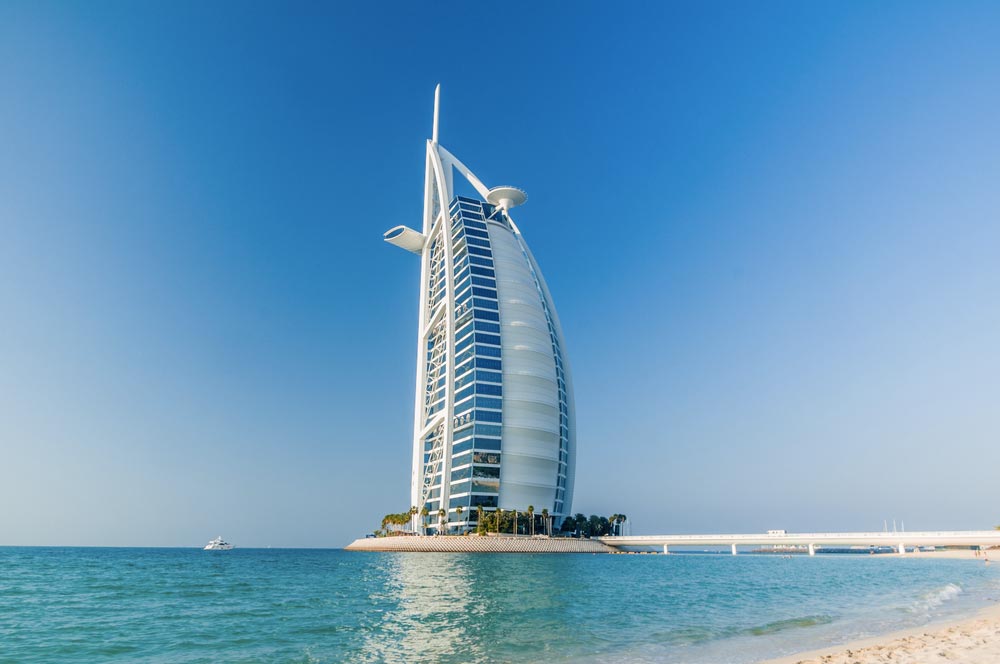 Hotel Burj al Arab ve tvaru plachty na umělém ostrově u dubajského pobřeží
