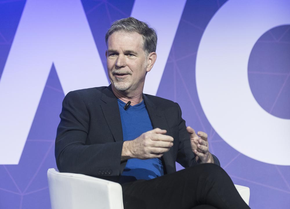 Reed Hastings, spoluzakladatel Netflixu, v černém saku při rozhovoru na konferenci