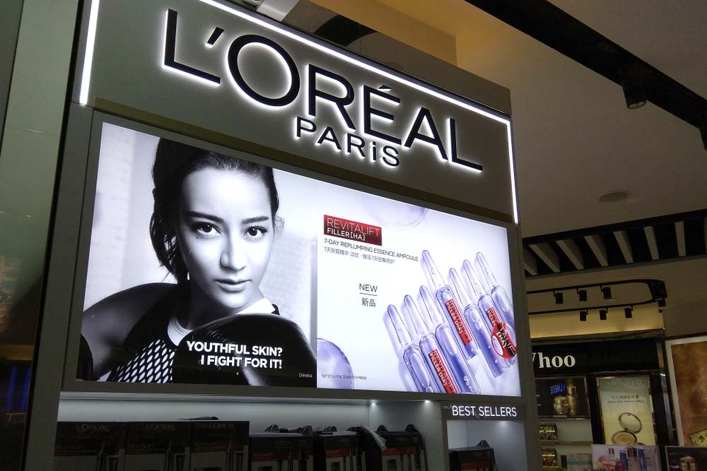 Světelný reklamní panel L'Oreal Paris s modelkou a produkty Revitalift v obchodním centru