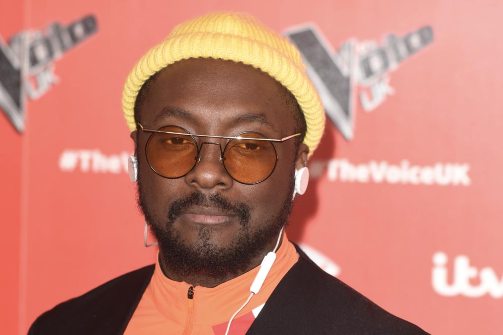 Will.i.am v žluté čepici a kulatých tónovaných brýlích na akci The Voice UK