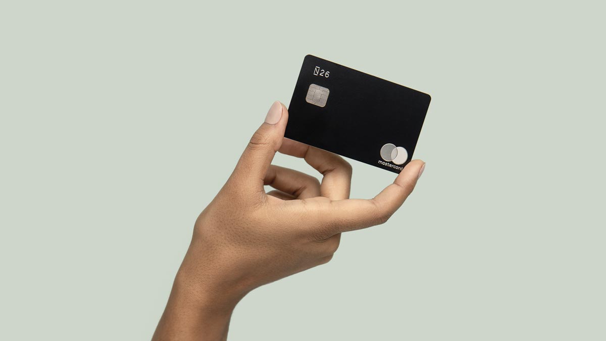 Ruka drží černou platební kartu N26 s cipem a logem Mastercard