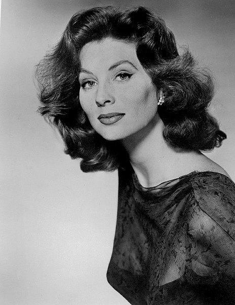 Černobílý dobový portrét modelky Suzy Parker s vlnitými vlasy a krajkovými šaty
