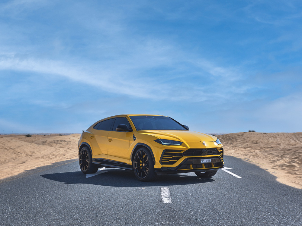 Žluté SUV Lamborghini Urus na silnici uprostřed pouště